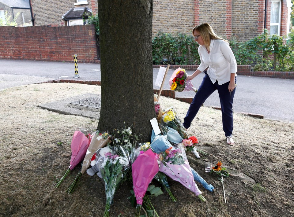 A woman places a bouquet of flowers at the crash site