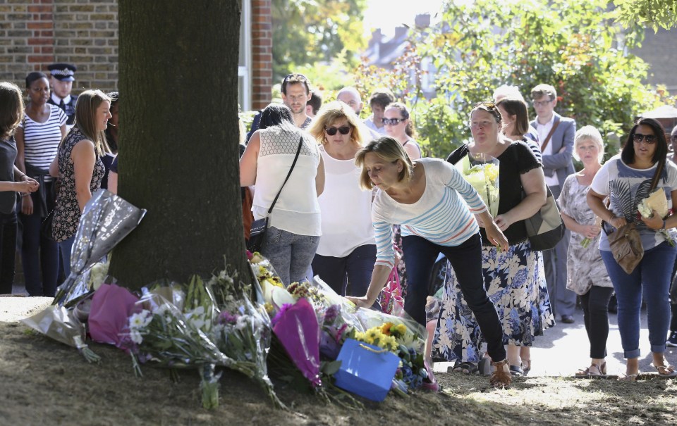 A group from Alexandra Junior School place flowers next to the tree in Penge