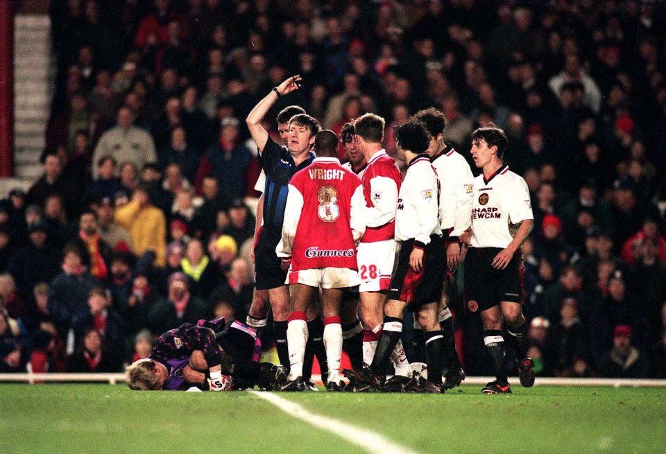 19 Feb 1997: Peter Schmeichel of Manchester United lies injured after clashing with Ian Wright of Arsenal during the FA Carling Pemiership match between Arsenal and Manchester United at Highbury, London. Mandatory Credit: Stu Forster/ALLSPORT