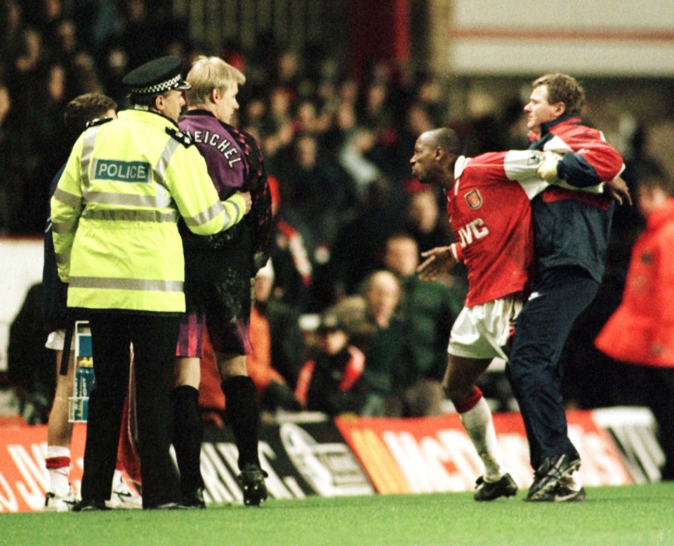 TIMES PIC MARC ASPLAND; THE MOMENT IAN WRIGHT IS RESTRAINED BY GARY LEWIN - THE ARSENAL PHYSIO - AS PETER SCHMEICHEL IS HELD BACK BY THE POLICE AS THE PLAYERS LEAVE THE PITCH AT HIGHBURY. Arsenal v Manchester United.