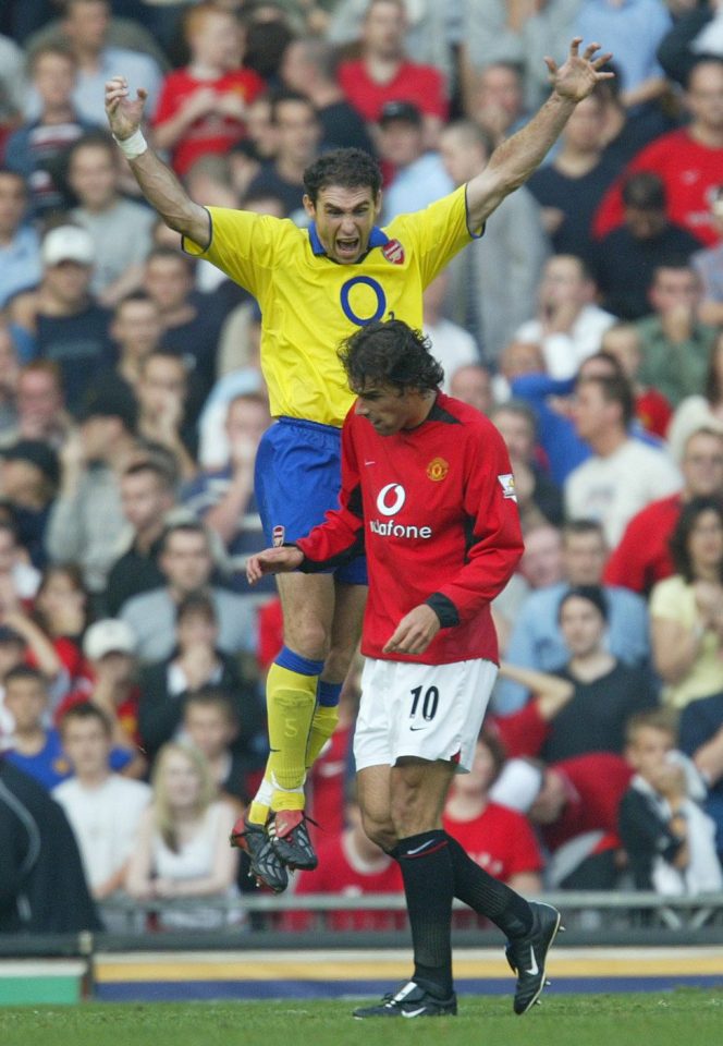 ARSENAL'S MARTIN KEOWN JUMPS FOR JOY IN A DRACULA LIKE STYLE ABOVE THE DEJECTED MANCHESTER UNITED PLAYER RUUD VAN NISTELROOY AFTER THE FINAL WHISTLE.MANCHESTER UNITED V ARSENAL 21ST SEPTEMBER 2003. PICTURE BY MARK ROBINSON/THE SUN. What The Papers Say Sports Photographer of the Year Award 2003.