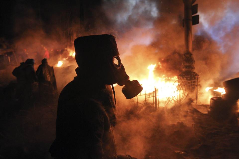 Anti-government protesters gather at a barricade at the site of clashes with riot police in Kie