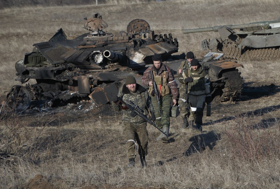  Russia-backed separatists inspect damaged Ukrainian tanks near Debaltseve in February last year