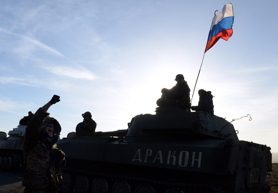 A Russian flag flies near Pro-Russia militants sitting atop a 2S1 Gvozdika (122-mm self-propelled howitzer) as a convoy of pro-Russian forces takes a break as they move from the frontline near the eastern Ukrainian city of Starobeshevo 