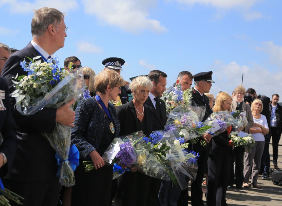  People wait to leave floral tributes on the Toll Bridge in Shoreham, West Sussex, ahead of a memorial to mark the one year anniversary in August