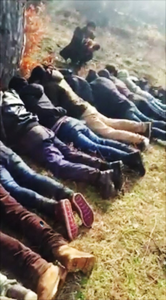 Other groups of men are shown lined up on the ground after Valev's group of vigilantes have arrested them