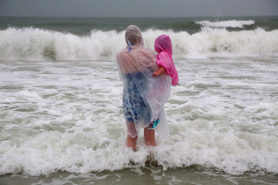  Lisa Bolton, from England, holds her three-year-old daughter during a visit to Clearwater Beach, Florida