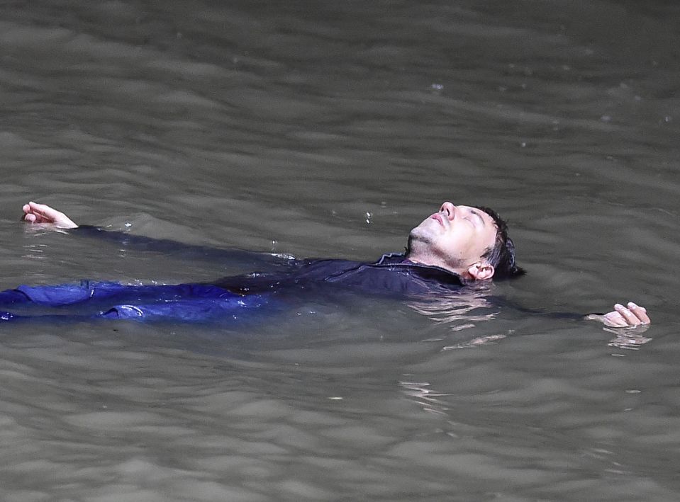 Teaser shots show him lying motionless in a huge lake