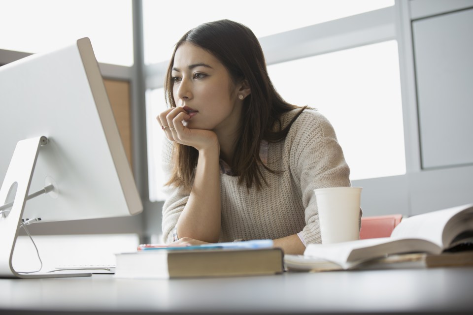 Focused college student studying at computer