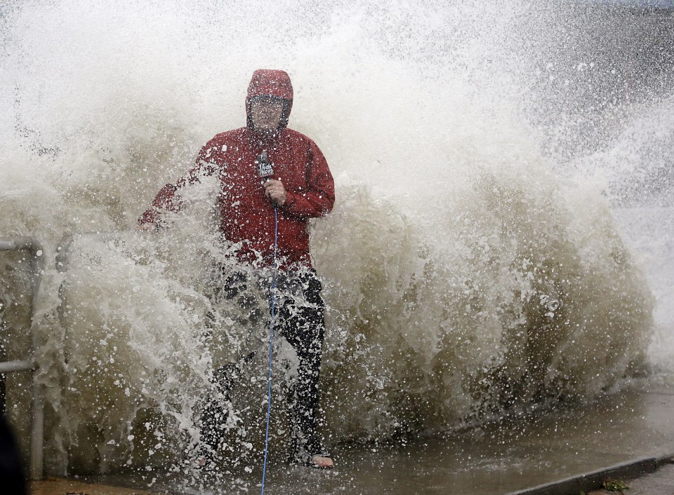  A news reporter doing a stand up near a sea wall in Cedar Key, Florida