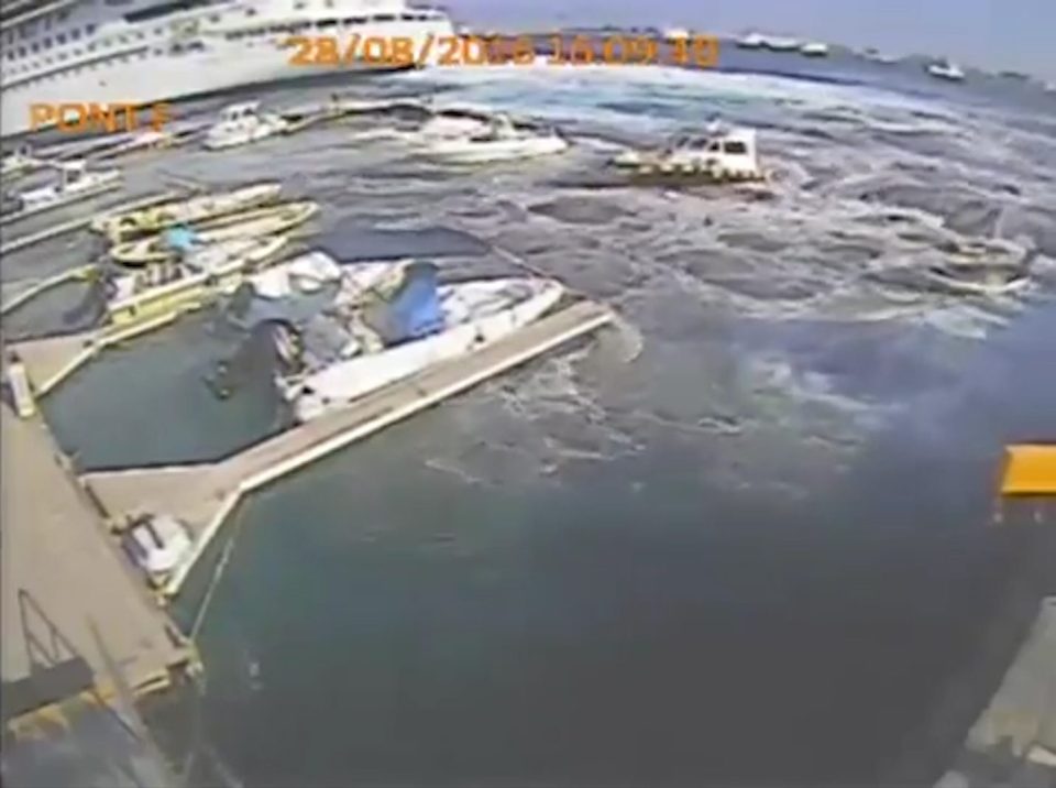 The Costa Vista cruise ship's propellers send a powerful wash crashing into the quiet marina