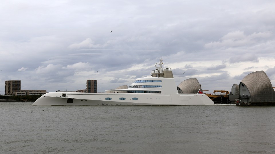 Power Yacht A moves through the Thames Barrier, dwarfing the large structures which straddle the River Thames