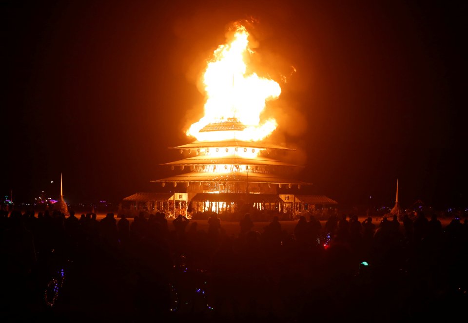 Participants watch the Temple Project burn as approximately 70,000 people from all over the world gathered for the 30th annual Burning Man arts and music festival in the Black Rock Desert of Nevada, U.S.