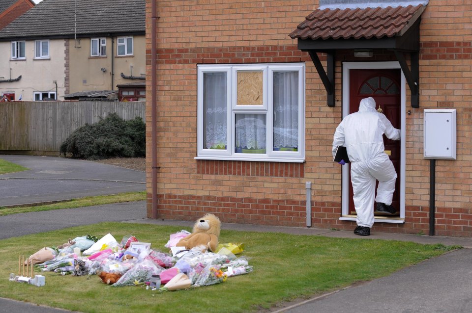  Floral tributes are left as forensics investigate the victims'  home in Spalding