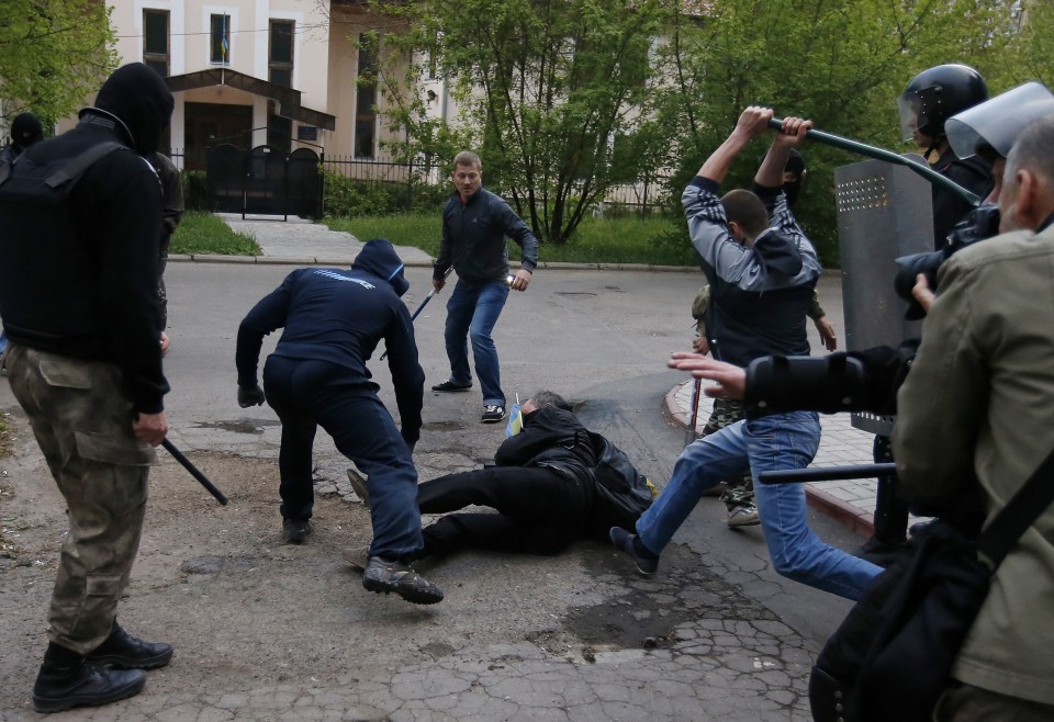 Pro-Russian protesters attack a pro-Ukranian protester during a pro-Ukraine rally at Donetsk 