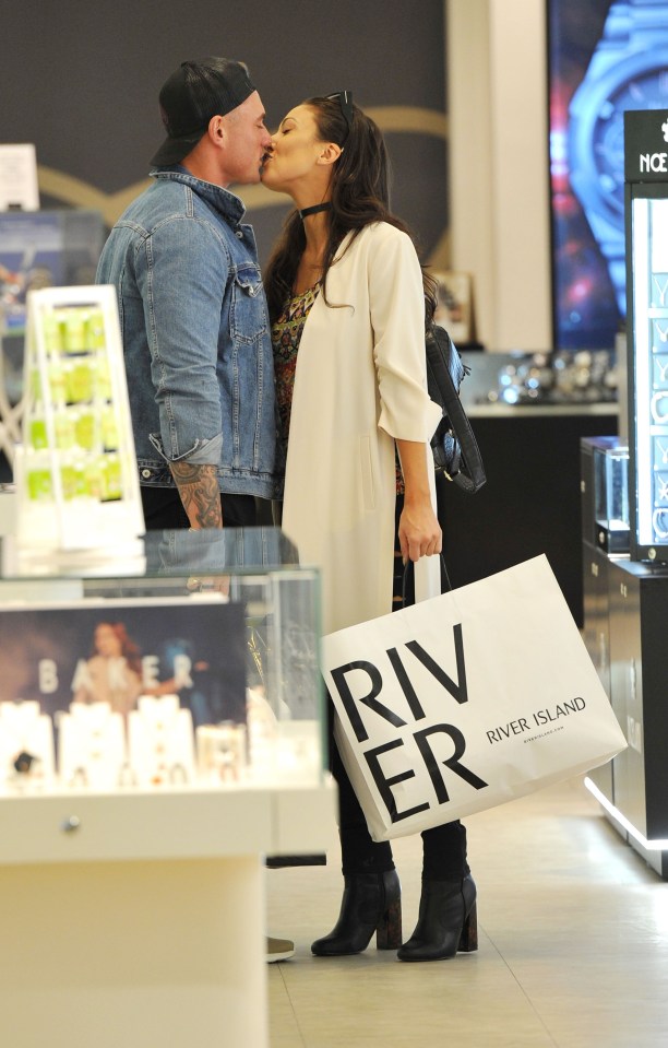  The loved-up couple puckered up while shopping