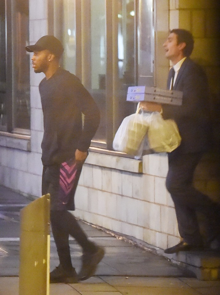 Sturridge leaves Il Forno restuarant in Liverpool with a staff member carrying his food to the car