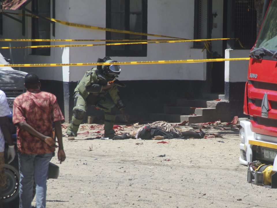 A member of the Kenyan bomb squad inspects the bodies of women who were shot dead by police after trying to stage an attack at the Central Police Station