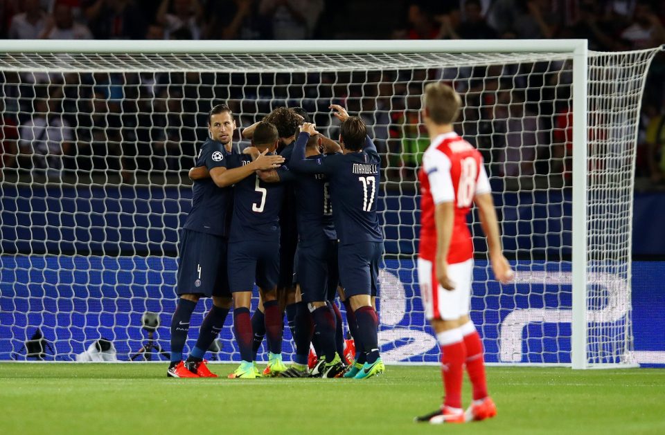 Nacho Monreal watches on as PSG players mob Edinson Cavani after he opened the scoring in the first minute