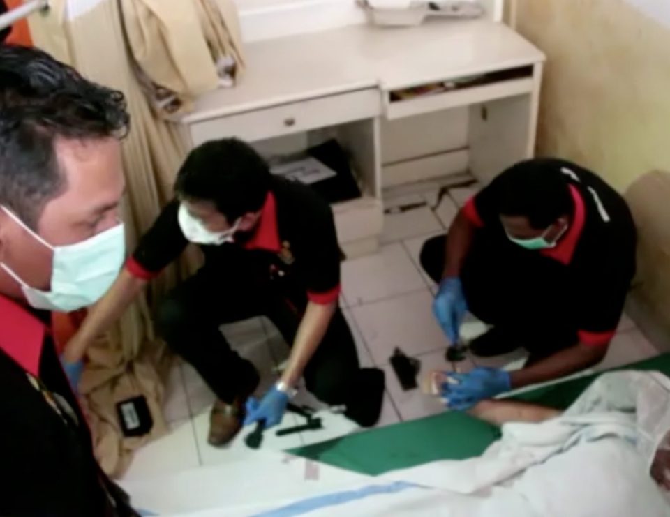  Paramedics examining the body of one of the victims killed on the boat