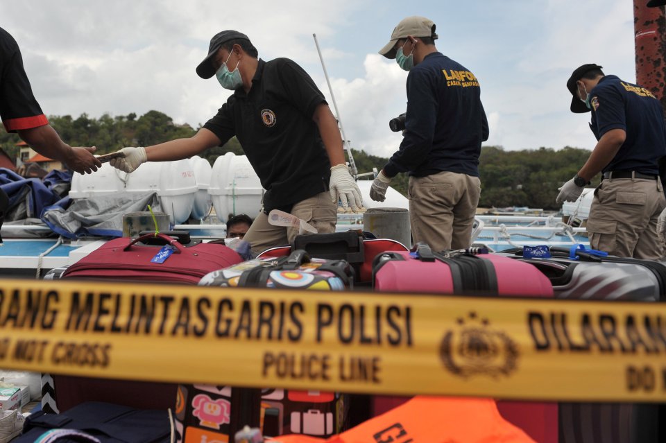  A police forensic team examines the boat