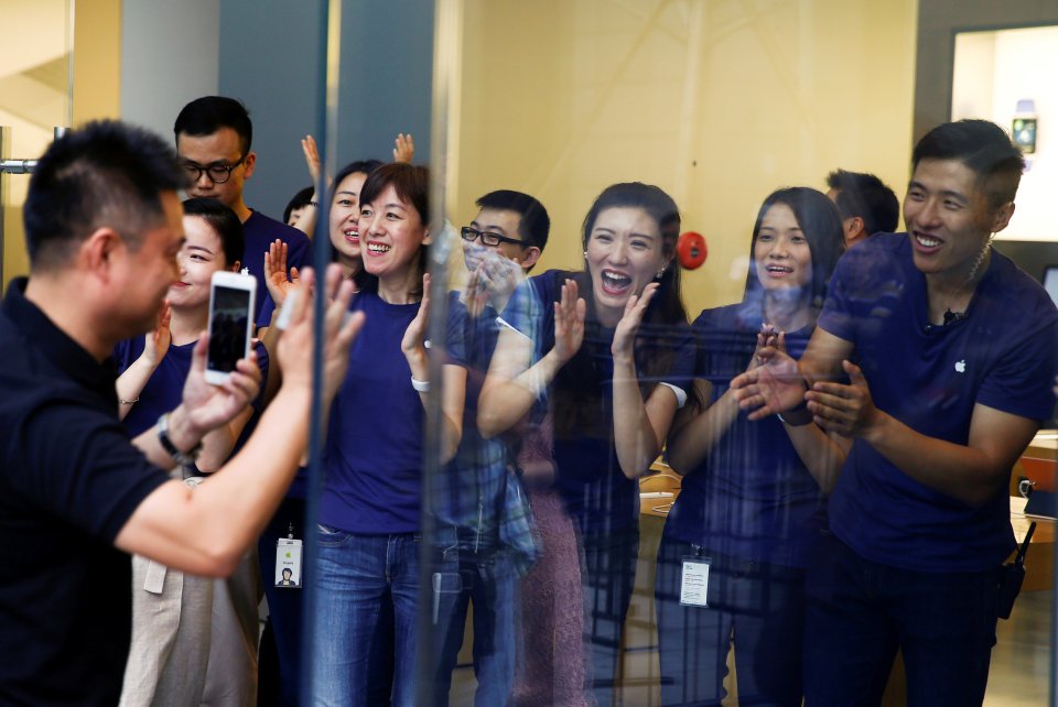  CHINA ... Staff members applaud a customer as he arrives to purchase Apple's new iPhone 7 at an Apple store in Beijing