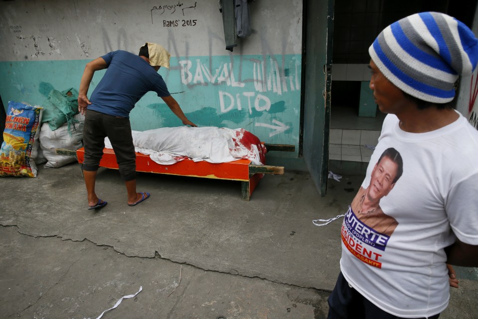  The body of a suspected dealer lies covered with a blanket in the streets of Manila