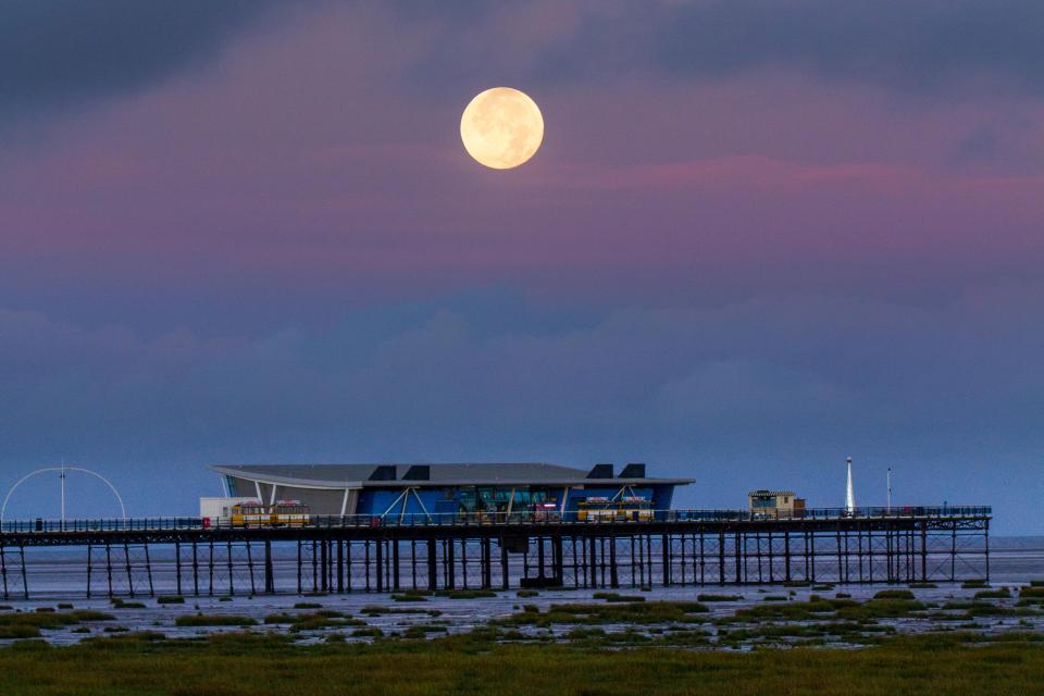  The Harvest Moon lunar eclipse is when the moon falls into the shade of the earth, making it darker (Pictured: Southport, Merseyside)