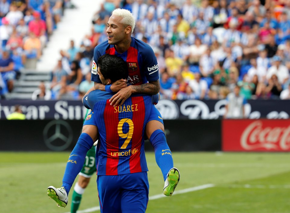  Neymar jumps on Luis Suarez after the latter assisted his goal