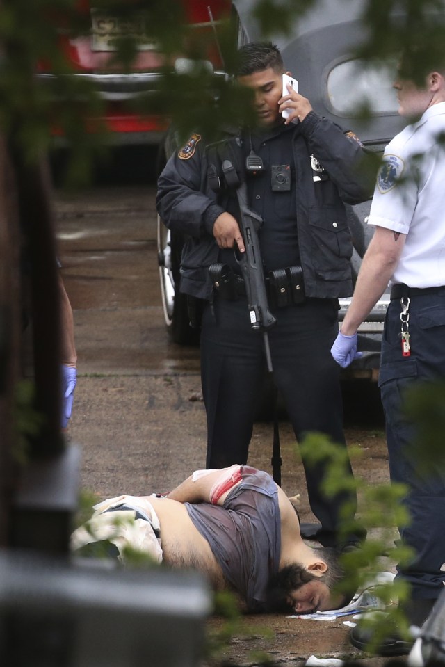  Horror attack . . . police officer stands over injured bomb suspect