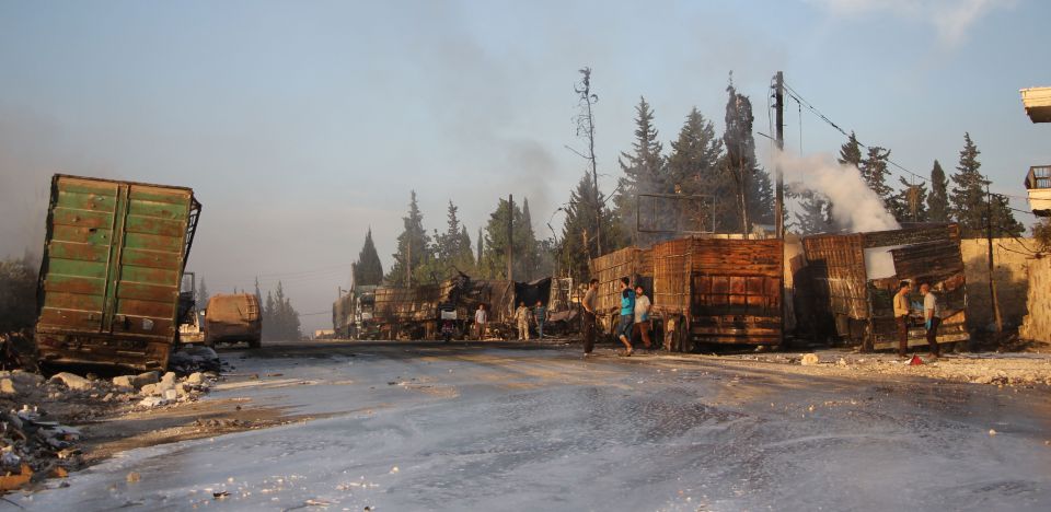  Syrians gather near the damaged trucks