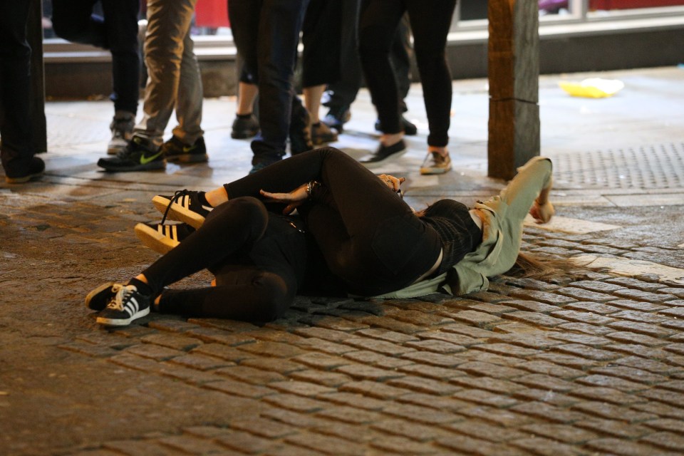  A pair have a hug in the Liverpool road as another person joins a girl who has taken a tipsy tumble