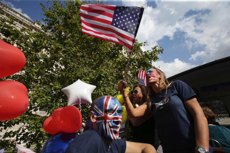  Activists wave US flags atop a "Stop Trump" battle bus as it passes St Paul's Cathedral