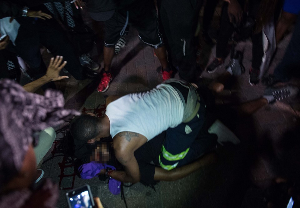  A man attends to a protester who was shot during a demonstration against police brutality