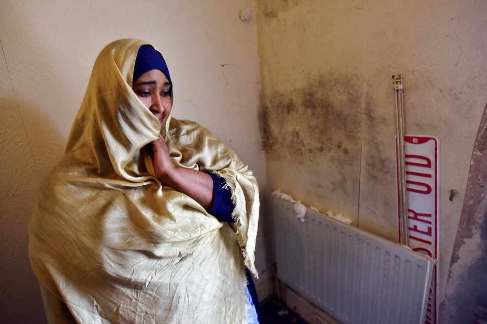  Nimo Abdullahi beside the damp in her home that caused her to complain