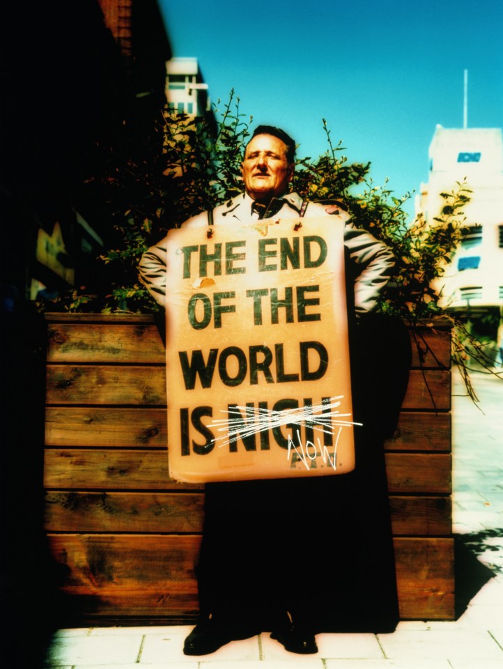 Man wearing sandwich board sign on street