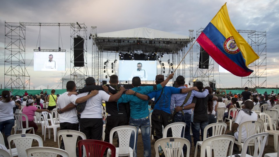  Men embrace and hold a Colombian flag during an event organized by rebels of the Revolutionary Armed Forces of Colombia (FARC) in the Yari Plains of southern Colombia