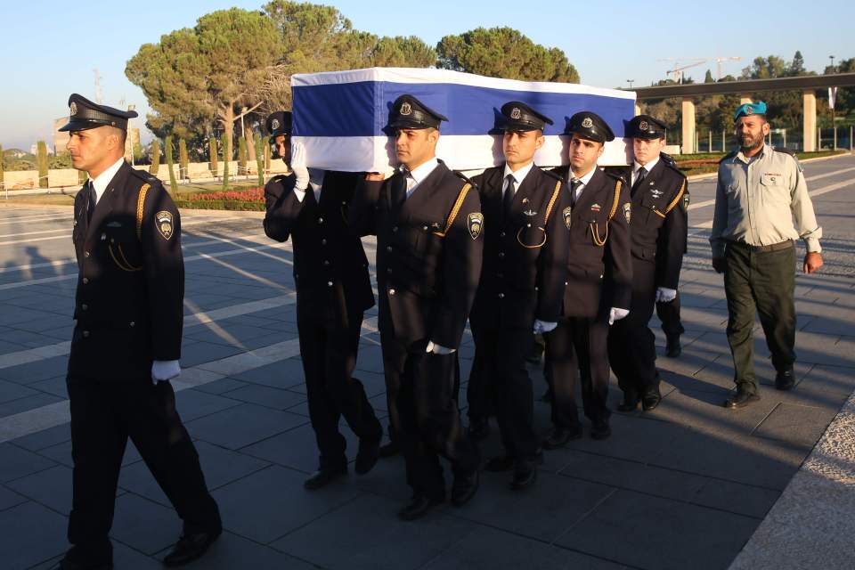 Israeli honour guards carried the coffin of the former president to where he will lie in state