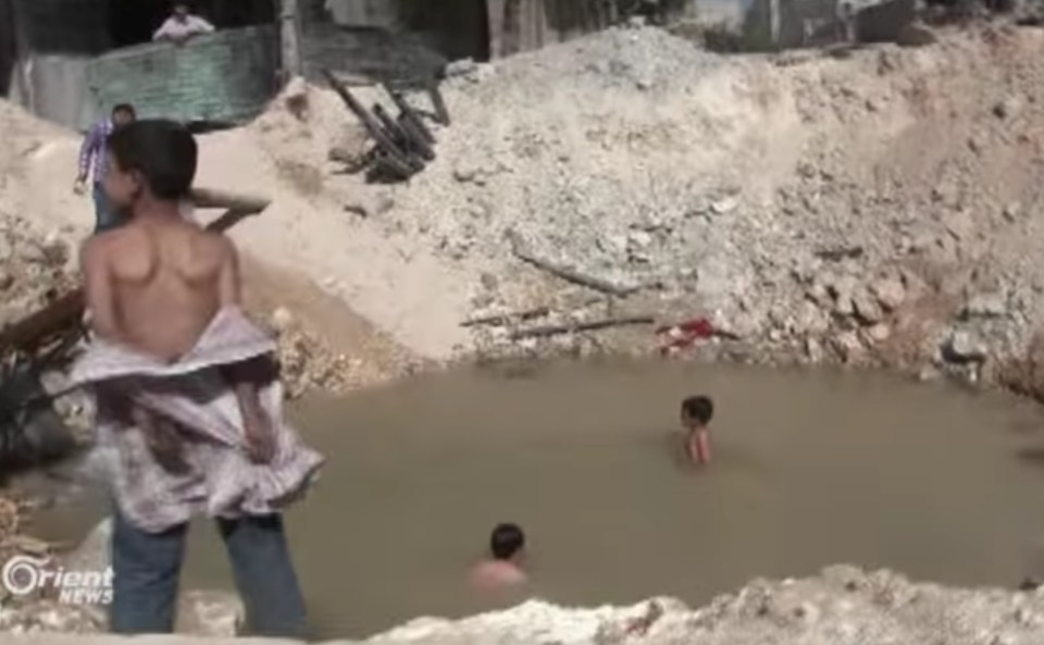 Children swim in a crater 