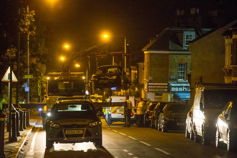  A police tow truck lifts a crashed Ford Fiesta car into the air in Lennard Road Penge. The car was reportedly being chased by police when it mounted the kerb killing a woman and a child.