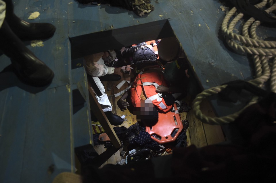 Members of Proactiva Open Arms NGO prepare to evacuate a dead body on a stretcher from the third level of a wooden vessel during a rescuing operation in the Mediterranean Sea, some 12 nautical miles north of Libya, on October 4, 2016. At least 1,800 migrants were rescued off the Libyan coast, the Italian coastguard announced, adding that similar operations were underway around 15 other overloaded vessels. / AFP PHOTO / ARIS MESSINISARIS MESSINIS/AFP/Getty Images