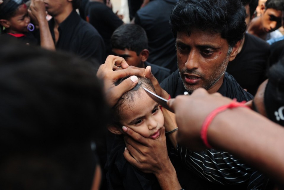  A young Shia Muslim child is flagellated during the mourning procession on the tenth day of Muharram, which marks the day of Ashura, in Chennai