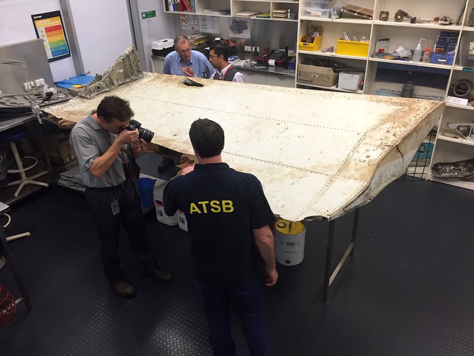 Australian and Malaysian officials examine aircraft debris at the Australian Transport Safety Bureau headquarters in Canberra earlier this year