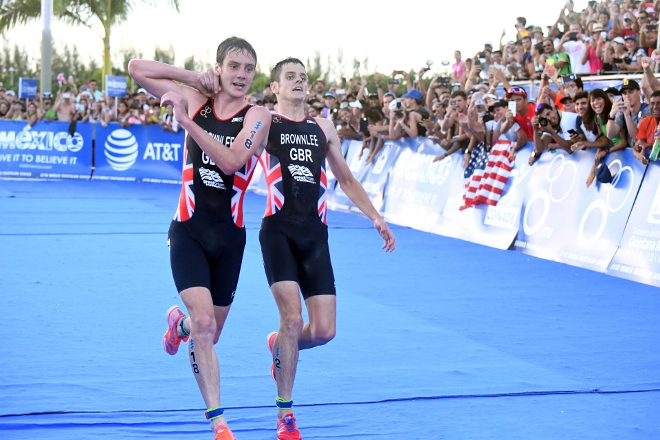 Alistair Brownlee, left, helps his brother Jonny to get to the finish line during the Triathlon World Series event in Cozumel, Mexico