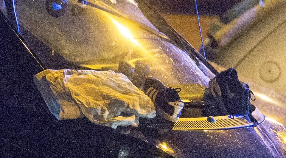  A shoe lies against the windscreen of a car at the scene