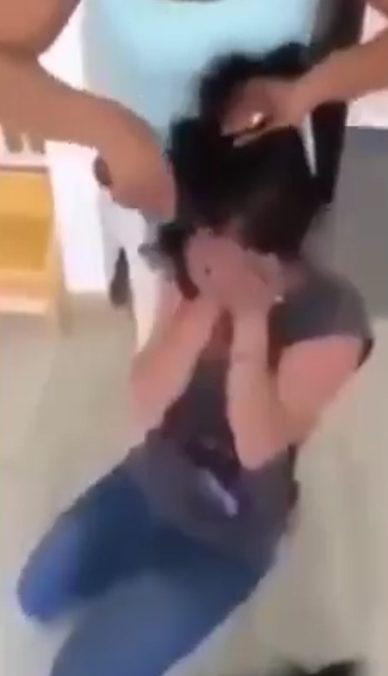  Weeping ... Girl screams as her mum coolly begins cutting her hair off