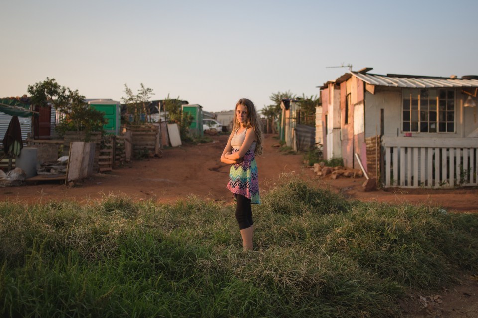  Jeanine Maritz, 13, stands down the road from her mother's makeshift home. She lives with her father and visits her mother and aunt in Munsieville squatter camp on weekends and holidays