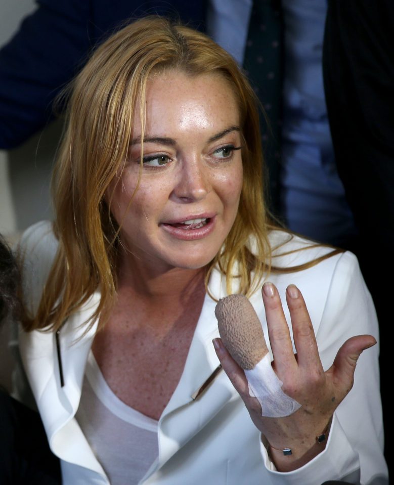 Lindsay Lohan, pictured with a Syrian refugee, displays her bandaged finger