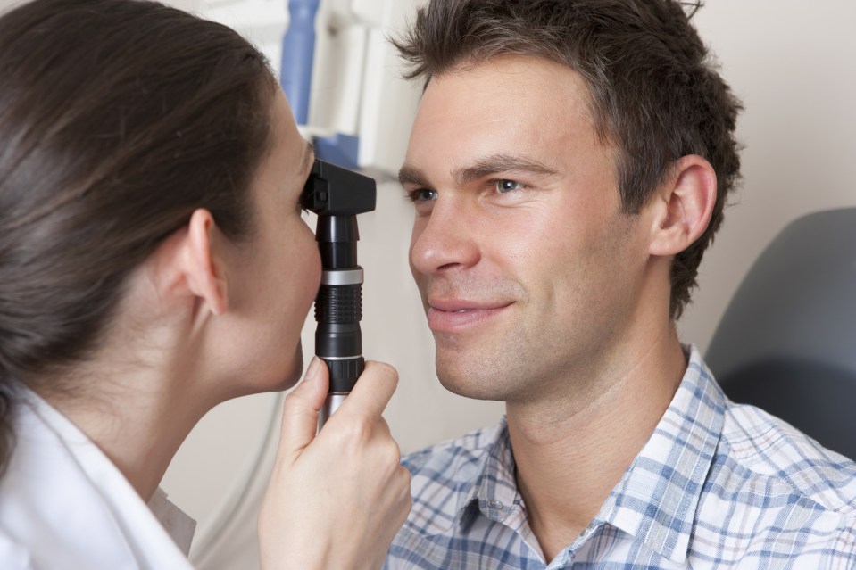 Close up of optometrist examining patient's eyes with eye test equipment