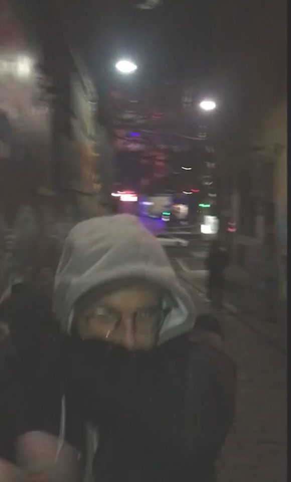 The man, dressed in a hoodie makes a run for it after he is rumbled down the alley during the middle of the night